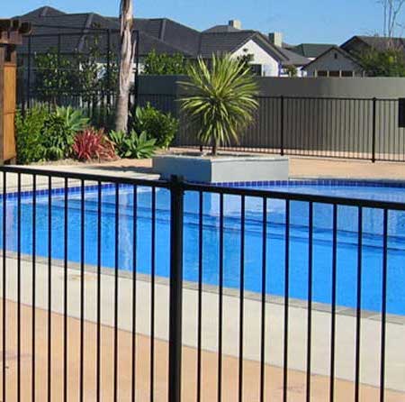 Black aluminum picket fencing surrounding an outdoor pool