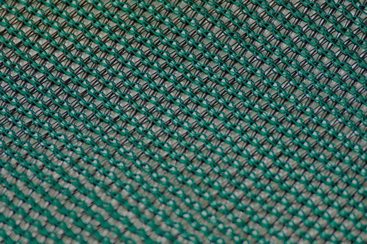 Close-up of green knitted shade netting showing yarn and mesh openings