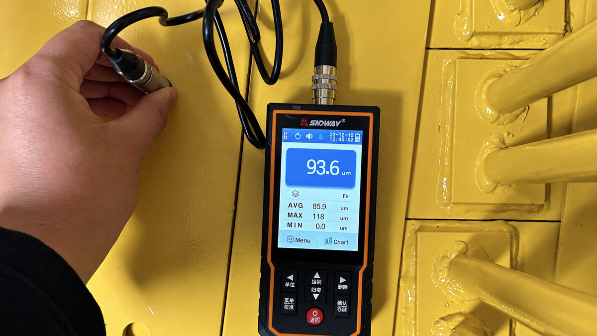 AI-retouched illustration based on a coating-thickness inspection photo, showing a probe and digital gauge on a yellow metal component.