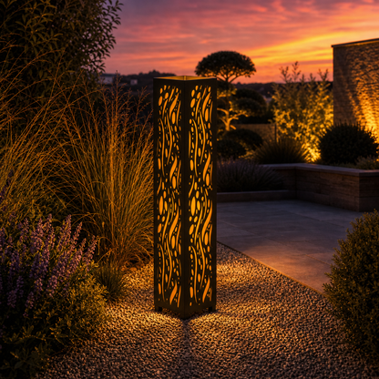 Design 052 outdoor decorative LED light column glowing at dusk in garden setting