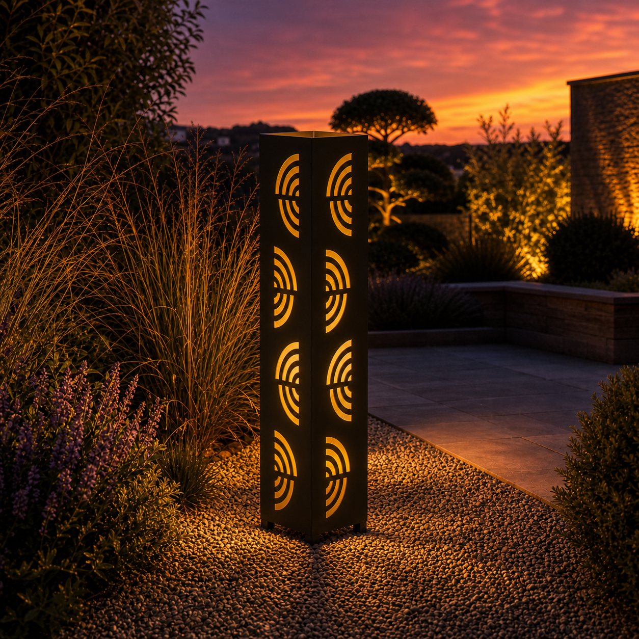 Design 121 outdoor decorative LED light column glowing at dusk in garden setting