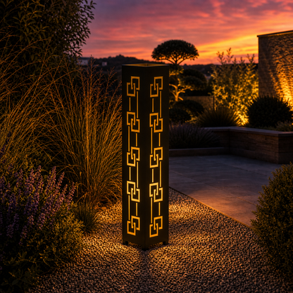 Design 129 outdoor decorative LED light column glowing at dusk in garden setting