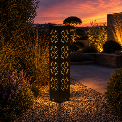 Design 130 outdoor decorative LED light column glowing at dusk in garden setting